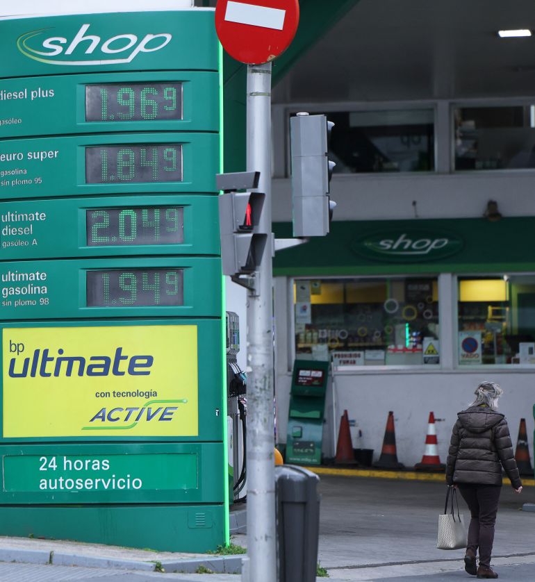 A woman walks past a billboard prices at a petrol station in Madrid on March 20, 2026.