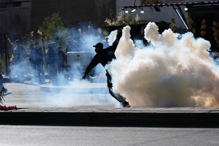 Security forces fire tear gas to disperse a protest against U.S. and Israeli attacks on Iran, at a bridge leading to the fortified Green Zone where the U.S. Embassy is located in Baghdad, Iraq, Sunday, March 1, 2026. (AP Photo/Hadi Mizban)