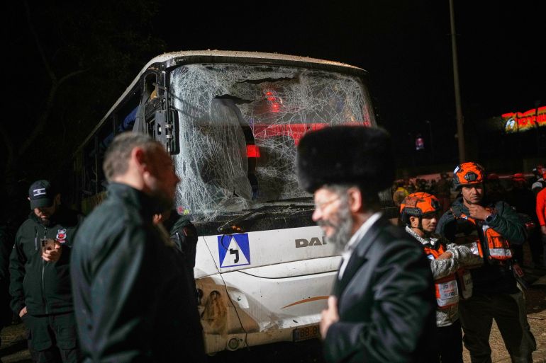 A damaged bus is seen as Israeli first responders work at the site struck by an Iranian missile in Arad, southern Israel, Sunday, March 22, 2026. (AP Photo/Ohad Zwigenberg)