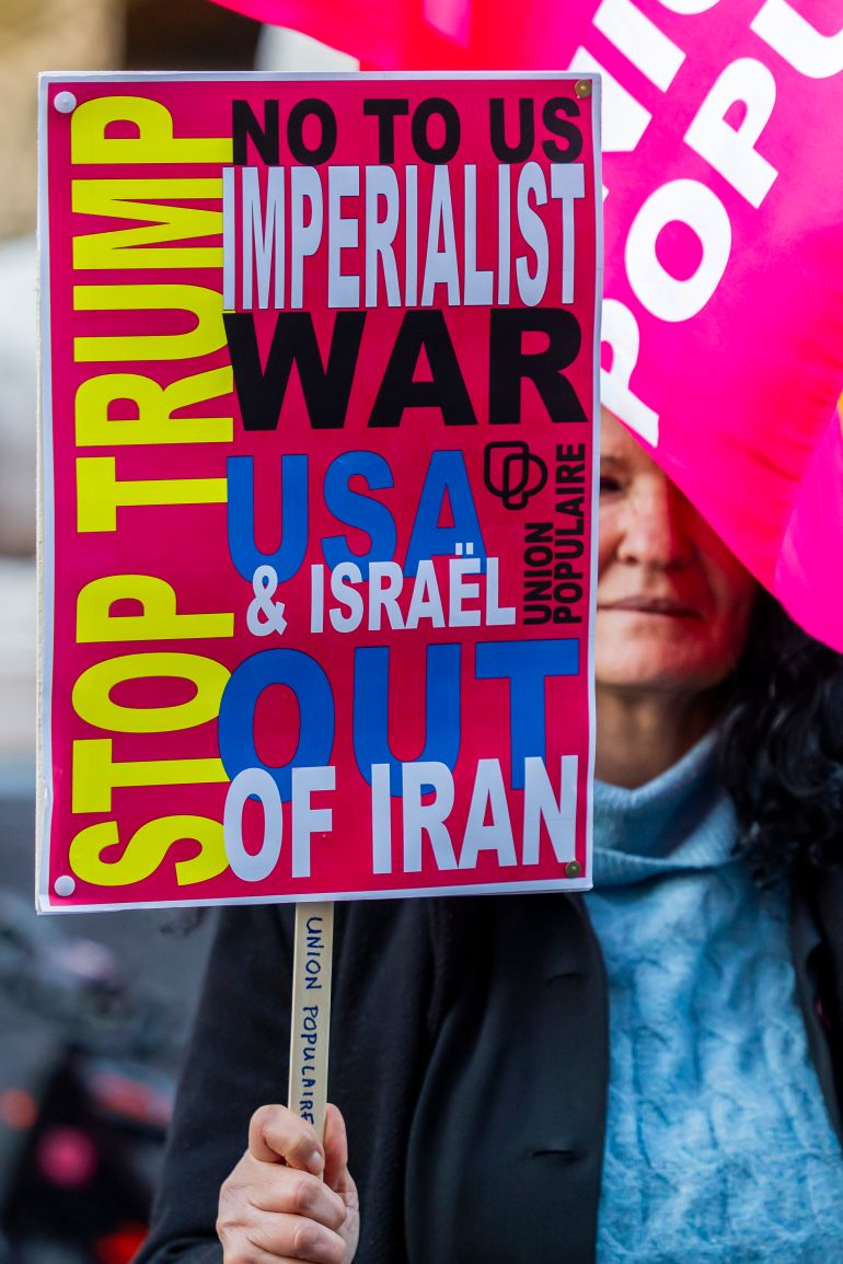  متظاهرة ترفع لافتة كُتب عليها "لا للحرب الإمبريالية الأمريكية ضد إيران" (الأوروبية)