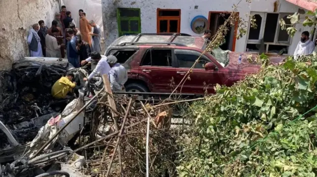 أشخاص متجمعون حول آثار غارة جوية في كابول