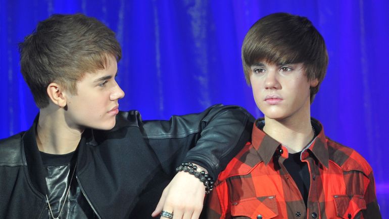 Canadian singer Justin Bieber (black top) poses with a waxwork model of himself during an official unveiling at Madame Tussauds wax museum in central London March 15, 2011. REUTERS/Toby Melville (BRITAIN - Tags: ENTERTAINMENT)
