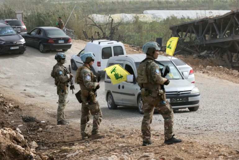 TOPSHOT - A French contingent of the United Nations Interim Force in Lebanon (UNIFIL) patrols the area as displaced residents waving Hezbollah flags make their way back to their homes on a makeshift road, built at the site where the Qasmieh bridge was destroyed in Israeli strikes, in the southern Lebanese area of Al-Qasmiyeh on April 18, 2026.