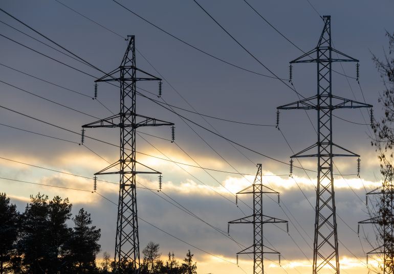 Interconnected Web of Electrical Towers Against a Sunset Sky