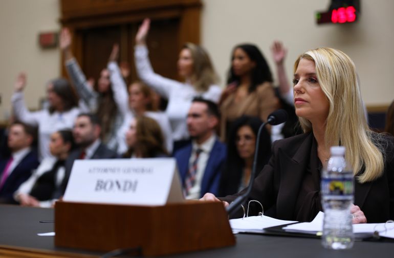 Attorney General Pam Bondi testifies before a House Judiciary Committee oversight hearing on Capitol Hill in Washington, Wednesday, Feb. 11, 2026, in Washington, as Jeffrey Epstein survivors, stand left. (AP Photo/Tom Brenner)
