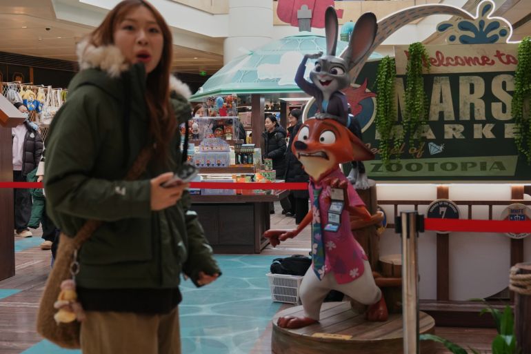 People shop at a booth selling merchandise of Disney's latest animation film "Zootopia 2" at a shopping mall, in Beijing on Saturday, Dec. 20, 2025. (AP Photo/Andy Wong)