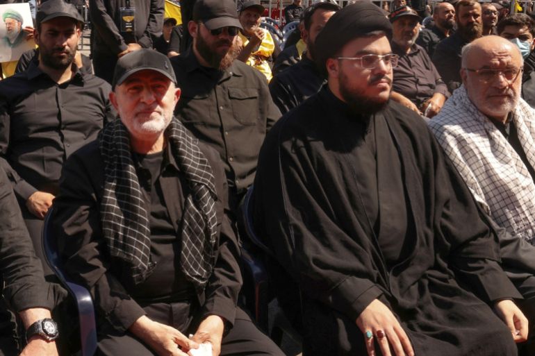 Hezbollah's security chief Wafiq Safa (L) and Muhammad Mahdi Nasrallah (C), son of slain Hezbollah leader Hassan Nasrallah, attend a mourning ritual on the tenth day of the Muslim month of Muharram as part of Ashura, a 10-day period commemorating the seventh century killing of Prophet Mohammed's grandson Imam Hussein, in Beirut's southern suburbs on July 6, 2025. (Photo by ANWAR AMRO / AFP)