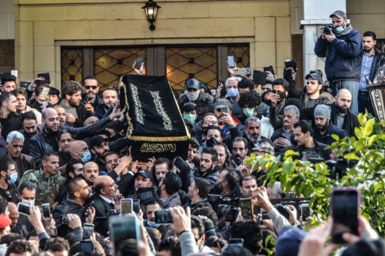 The casket of film director Hatem Ali is carried out from al-Hussein mosque in the Syrian capital Damascus, during his funeral on January 1, 2021. - Damascus today bid farewell to Hatem Ali, after the arrival of his remains from Cairo, where he died earlier this week of a heart attack. (Photo by Maher AL MOUNES / AFP)