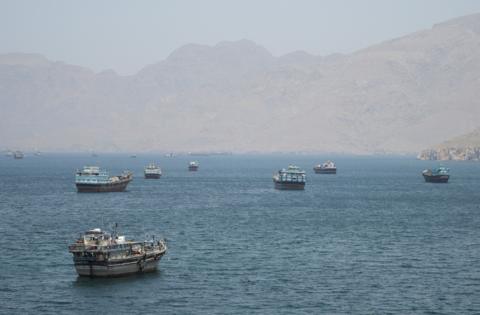 ترامب مرتديا بدلة سوداء ورابطة عنق حمراء يشير بيده إلى شي جين بينغ الواقف إلى جواره مرتدياً بدلة ورابطة عنق زرقاء وخلفهما أعلام الصين والولايات المتحدة