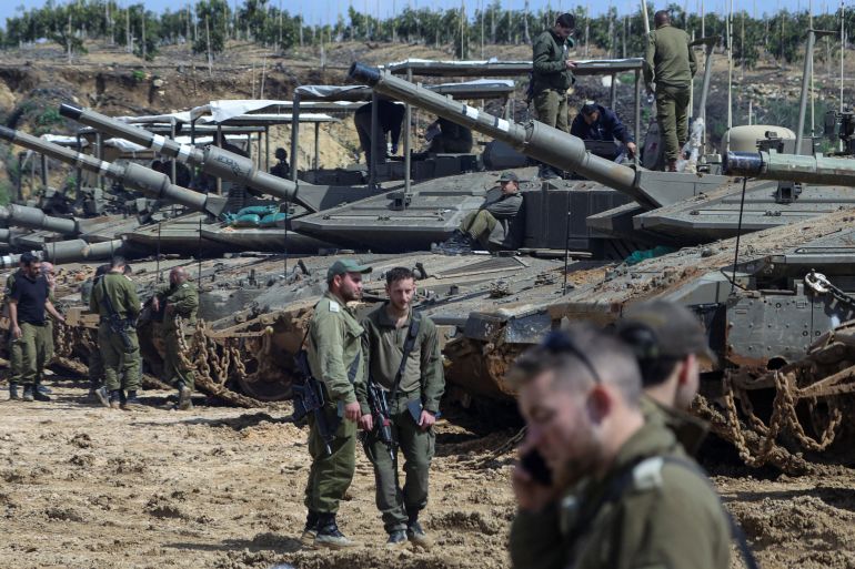 Israeli soldiers stand next to tanks near the Israeli side of the border with Lebanon, amid escalation between Iran-backed Hezbollah and Israel and the U.S.-Israeli conflict with Iran, in northern Israel, March 23, 2026. REUTERS/Tyrone Siu