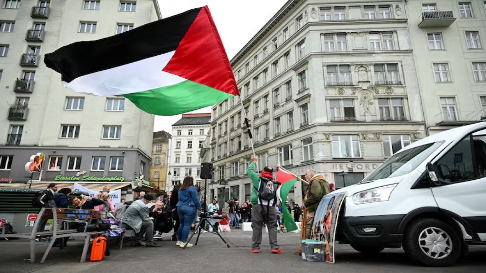 شخص يحمل علم فلسطين خلال احتجاج ضد مشاركة إسرائيل في مسابقة الأغنية الأوروبية "يوروفيجن" في فيينا. (رويترز)