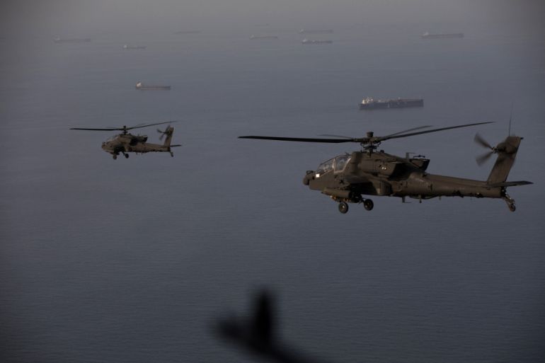 This handout photo released by US Central Command via their X account (@CENTCOM) on April 18, 2026 shows AH-64 Apaches flying above the Strait of Hormuz during a patrol on April 17, 2026.