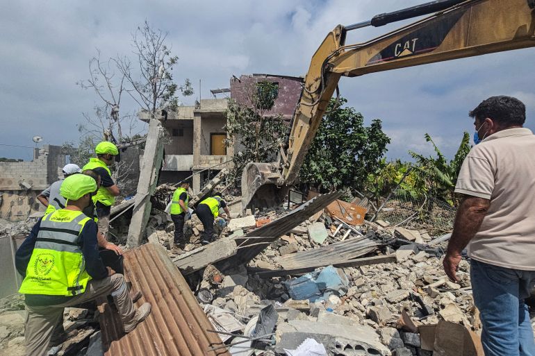 TOPSHOT - Civil defence members search for victims in the rubble of a residential building hit the previous day by an Israeli strike near the southern town of Burj al-Shamali, on the outskirts of Tyre, on May 27, 2026.