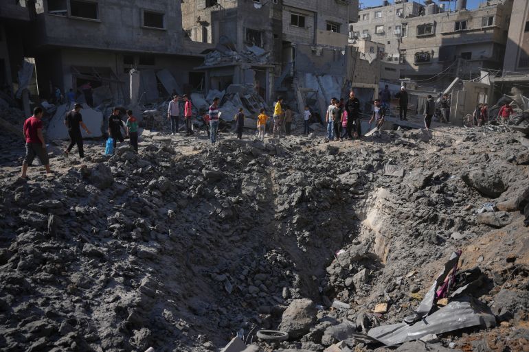 Palestinians stand by the rubble of a building that was destroyed by an Israeli airstrike at al-Bureij refugee camp in the central Gaza Strip, Saturday, May 23, 2026. (AP Photo/Abdel Kareem Hana)