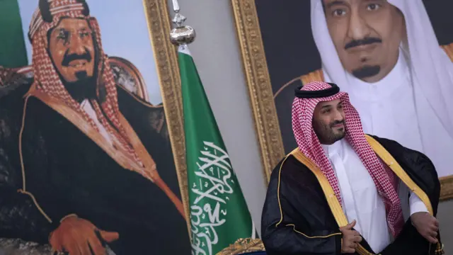 محمد بن سلمان أمام صور كبيرة.