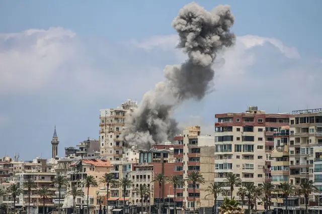 مبانٍ سكنية يتصاعد من بينها الدخان، بعد استهداف إسرائيلي لإحدى المناطق في مدينة صور، جنوبي لبنان.