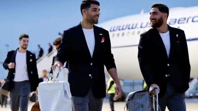 أعضاء المنتخب الإيراني لكرة القدم يرتدون سترات سوداء وتحتها تي شيرتات بيضاء ويحملون أمتعتهم بعد الوصول إلى المكسيك، ووضعوا على السترات شارة للرقم 168