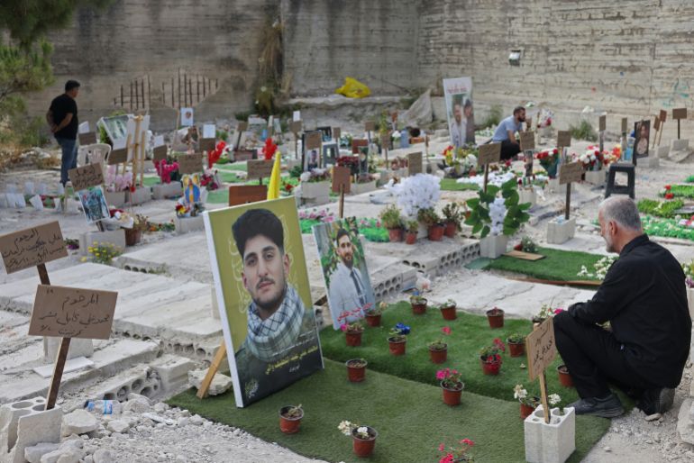 Hussein Tufayli (R) mourns over the grave of his son Mohammed Tufayli, a Hezbollah fighter who was killed during the ongoing war, at a temporary cemetery in the southern coastal Lebanese city of Sidon on June 11, 2026.