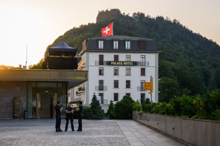 Police officers stand next to a building at the Burgenstock luxury hotel complex overlooking Lake Lucerne, Switzerland, on June 21, 2026, ahead of high-level talks aimed at advancing a deal to end the Middle East conflict.