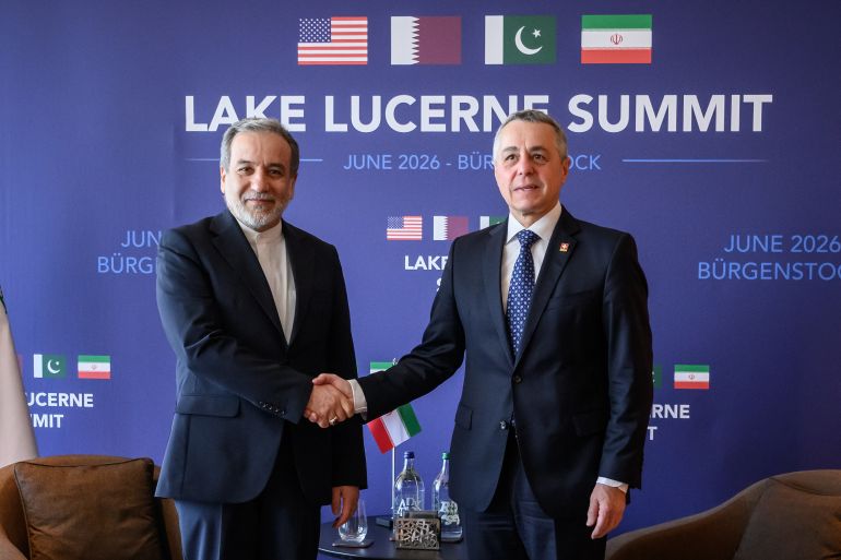 Iran's Foreign Minister Abbas Araghchi (L) shakes hands with Switzerland's Foreign Minister Ignazio Cassis at the Burgenstock luxury hotel complex overlooking Lake Lucerne, Switzerland, on June 21, 2026, ahead of high-level talks aimed at advancing a deal to end the Middle East conflict.
