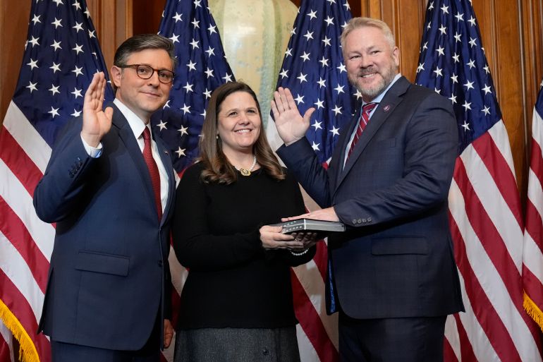 House Speaker Mike Johnson, R-La., left, poses during a ceremonial swearing-in with Rep. Warren Davidson, R-Ohio, right, in the Rayburn Room at the Capitol in Washington, Friday, Jan. 3, 2025. (AP Photo/Mark Schiefelbein)