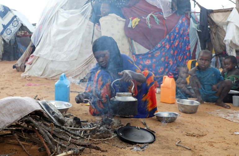 FILE PHOTO: An internally displaced woman prepares breakfast outside their makeshift shelter during a visit by World Food Programme’s Assistant Executive Director for Programme Operations, Matthew Hollingworth (not in the photo), to assess the knock on effects from the escalation in the Middle East, alongside drought and sharp cuts in humanitarian funding that are worsening hunger, in Kahda district of Mogadishu, Somalia May 7, 2026. REUTERS/Feisal Omar//File Photo