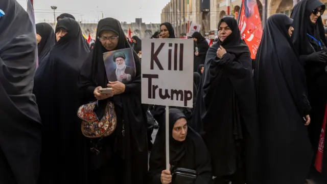 امرأة تحمل لافتة مكتوب عليها " اقتلوا ترامب"
