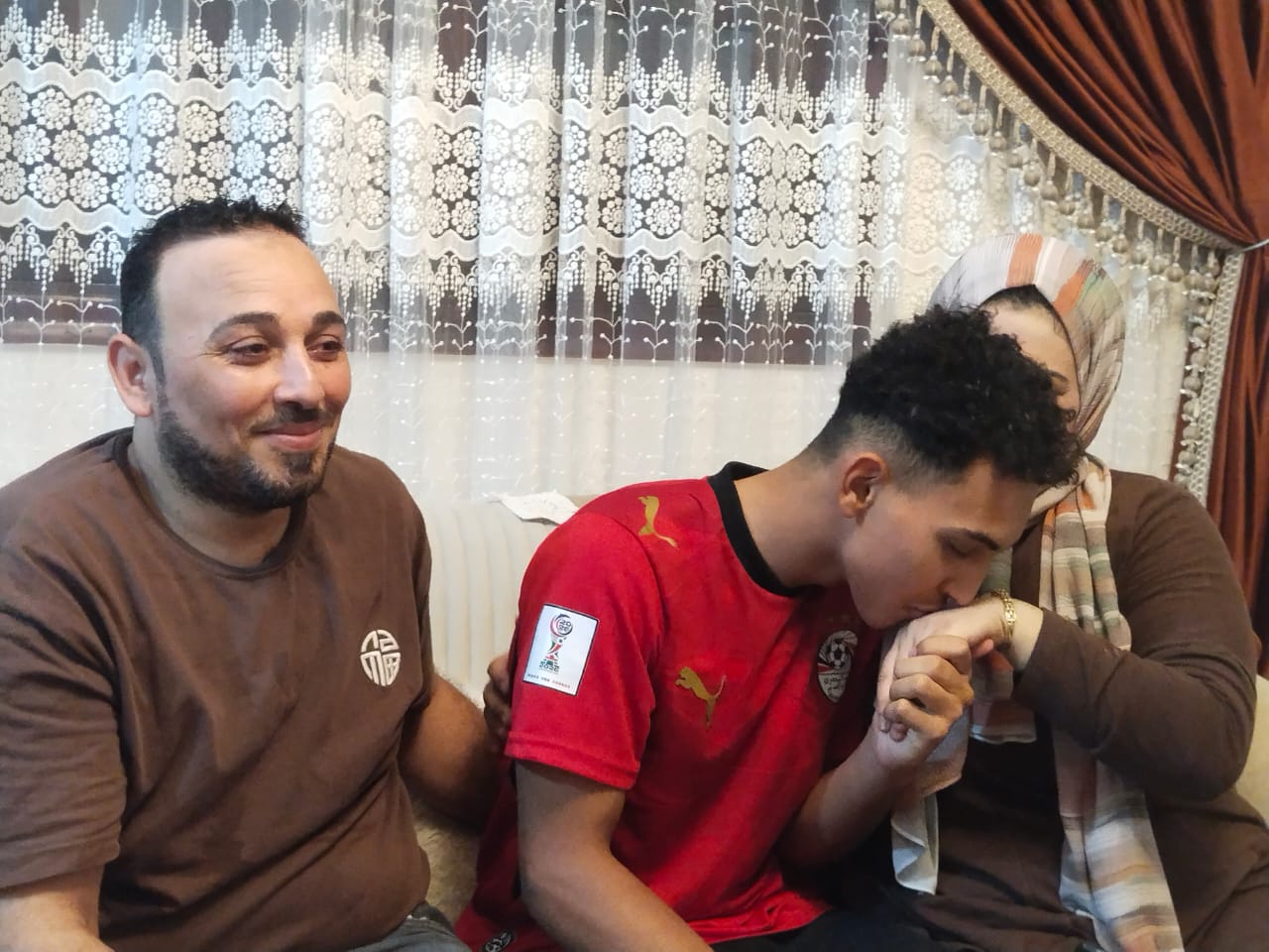 يقبل يد والدته