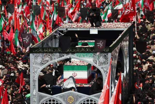 سيارة تحمل نعوش المرشد الأعلى الإيراني الراحل آية الله علي خامنئي وأفراد عائلته، تشق طريقها وسط موكب جنائزي حاشد في طهران، إيران، في 6 يوليو/تموز 2026، وقد نُثرت عليها الورورد