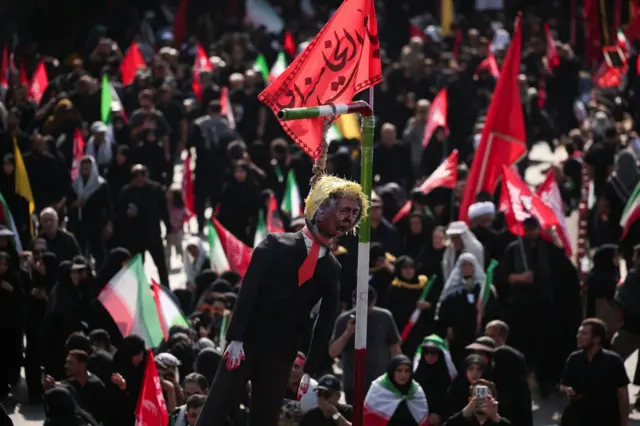 في طهران، إيران، بتاريخ 6 يوليو/تموز 2026، قام المشيعون بتعليق دمية تمثل الرئيس الأمريكي دونالد ترامب خلال تجمعهم في يوم جنازة المرشد الأعلى الإيراني الراحل آية الله علي خامنئي، الذي قُتل في 28 فبراير/شباط في غارات جوية إسرائيلية وأمريكية.