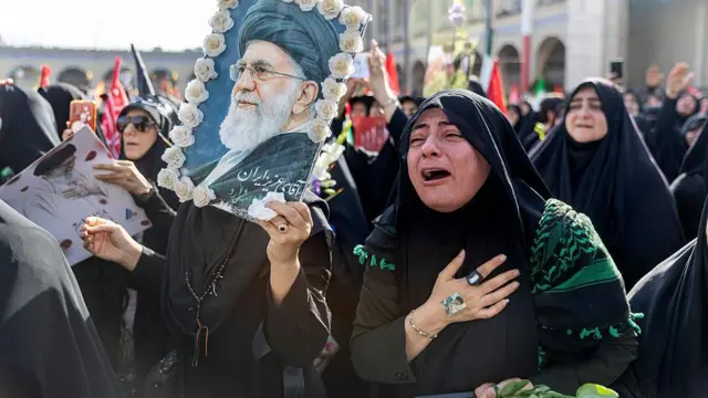 امرأة تبكي بينما يتجمع الناس في مصلى الإمام الخميني الكبير لحضور مراسم وداع آية الله علي خامنئي الراحل.