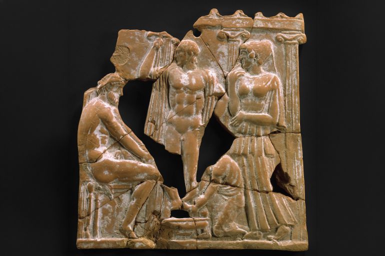 Terracotta plaque, Classical, ca 450 BC, Greek, Melian, Terracotta, Overall: 7 3/4 x 7 5/16 in (197 x 186 cm), Terracottas, Eurykleia washing Odysseus's feet One of the dramatic threads in the account of Odysseus's return to Ithaka is the gradual revelation of his identity Here, Odysseus appears seated before a columned facade that represents his palace. (Photo by: Sepia Times/Universal Images Group via Getty Images)