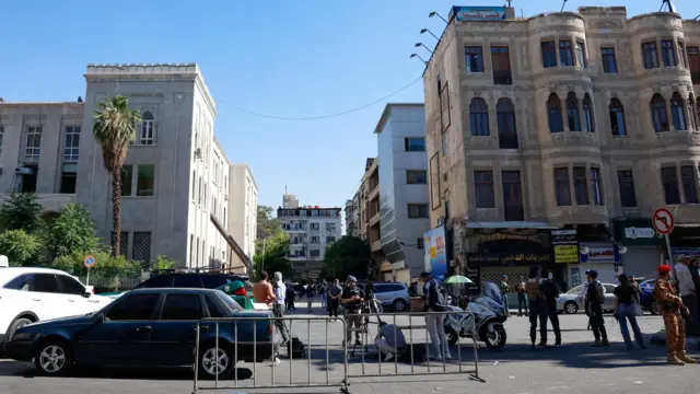 ممثلو وسائل الإعلام وأشخاص آخرون، يتجمعون بالقرب من موقع انفجار في مقهى بوسط دمشق، سوريا، في 2 يوليو/ تموز عام 2026.