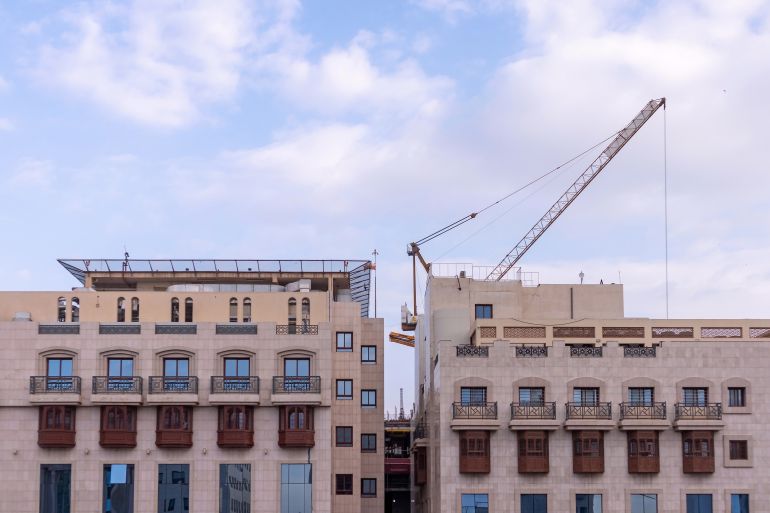 The top of a building of a residential or hotel a building under construction behind it with a crane أدوبي ستوك