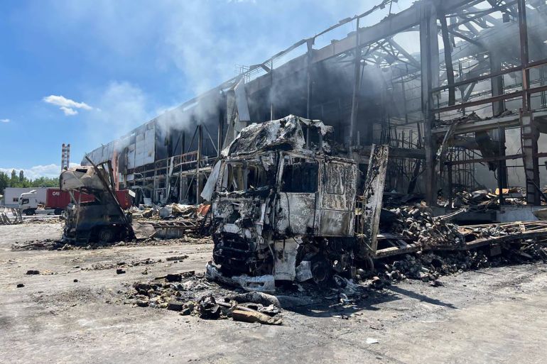 This handout photograph taken and released by the Ukrainian Red Cross on July 2, 2026 shows burnt-out trucks in front of a destroyed Red Cross warehouse following an air attack in Kyiv, amid the Russian invasion of Ukraine.