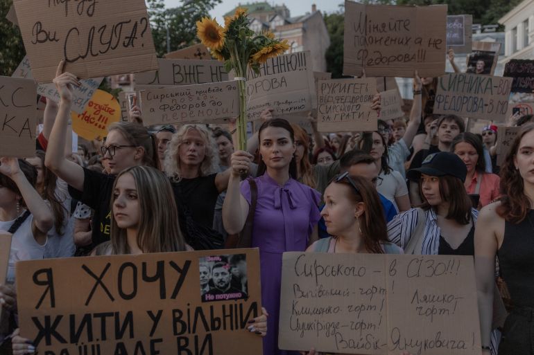 Protesters hold placards and chant slogans during a demonstration against Ukraine's President's decision to dismiss Ukraine's Defence Minister Mykhailo Fedorov, and demanding the dismissal of Ukraine's army chief Oleksandr Syrskyi, in Kyiv on July 18, 2026, amid the Russian invasion of Ukraine.