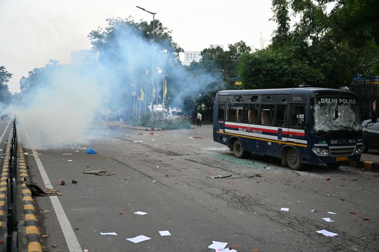 Tear gas is fired next to a damaged police vehicle as they clash with Cockroach Janta Party (CJP) supporters during a protest demanding the resignation of India's Education Minister Dharmendra Pradhan over alleged NEET exam irregularities in New Delhi on July 20, 2026.