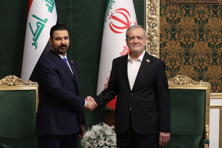 A handout picture provided by the Iranian Presidential Office on July 23, 2026, shows Iranian President Masoud Pezeshkian (R) shaking hands with Iraqi Prime Minister Ali al-Zaidi as he welcomes him in the Iranian capital Tehran.