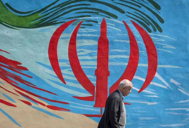 جل يمرّ أمام جدارية في طهران، إيران، في 30 مارس/آذار 2026. تُعبّر الجدارية عن دعمها للعمليات ضد التحالف الأمريكي الإسرائيلي.