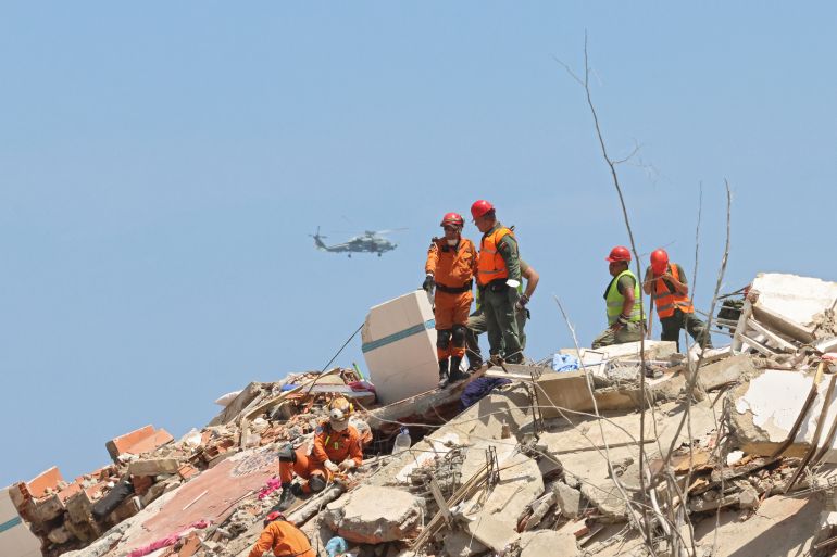 LA GUAIRA, VENEZUELA - JULY 01: Rescuers continue with the search and rescue efforts as a helicopter flies in the background after a magnitude 7.2 earthquake struck Venezuela and other regions in the Caribbean, on July 01, 2026 in La Guaira, Venezuela. According to the U.S. Geological Survey (USGS), the main earthquake on June 24, 2026 was followed by a 7.5-magnitude aftershock less than a minute later. The number of fatal victims increased to 2295, while the number of injured people exceeded 10,000. More than 70,000 people are reported missing. (Photo by Edilzon Gamez/Getty Images)