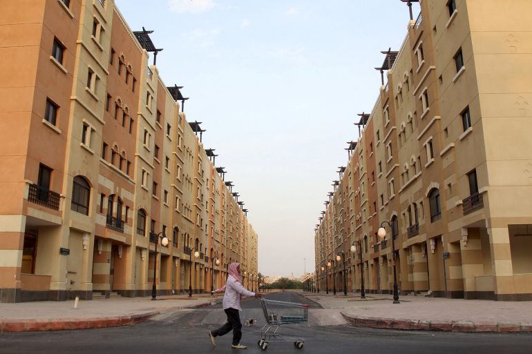 A man pushes a cart as he walks past residential buildings in Riyadh, Saudi Arabia December 21, 2015. Picture taken December 21, 2015. REUTERS/Faisal Al Nasser