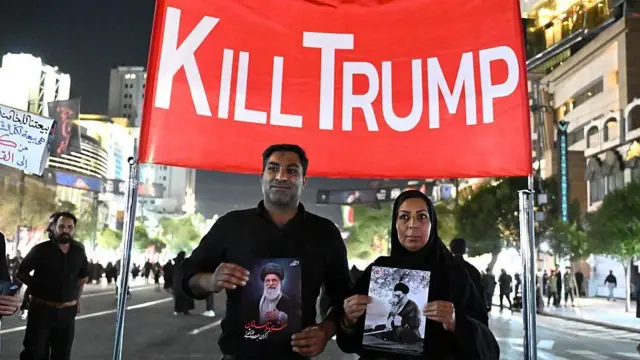 يرفع مشيعون لافتة مناهضة للولايات المتحدة لدى وصولهم إلى محيط ضريح الإمام الرضا للمشاركة في مراسم تشييع الزعيم الإيراني الراحل علي خامنئي وأفراد من عائلته في مدينة مشهد، في وقت مبكر من يوم 9 يوليو 2026.