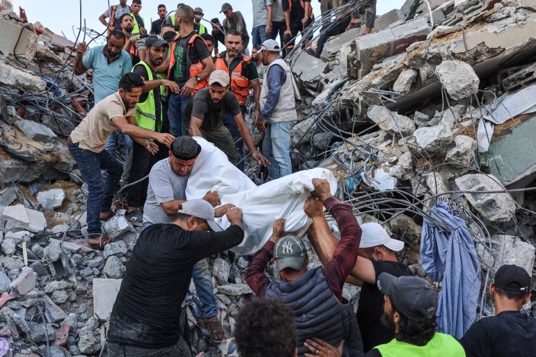Volunteers and rescuers carry a body recovered from the rubble of a collapsed building in the Tal al-Hawa area of Gaza City on September 16, 2026.