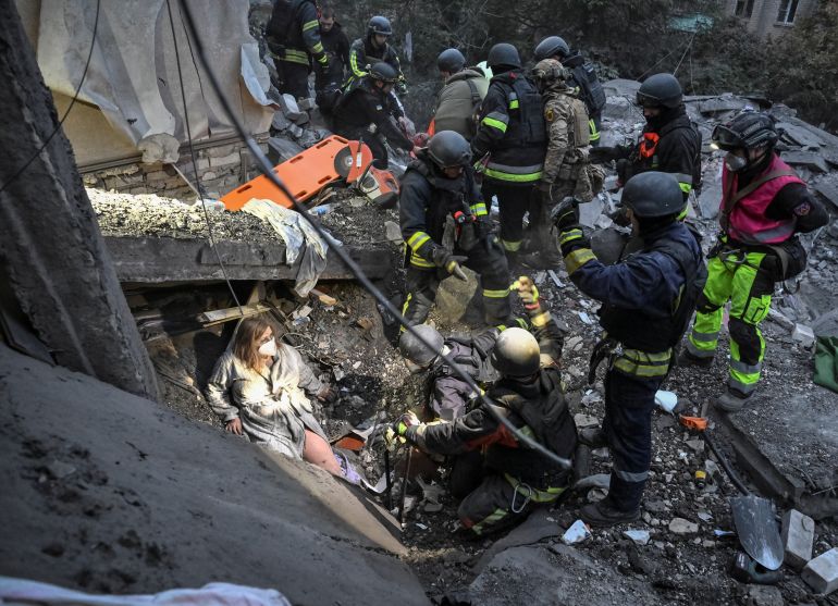 Rescuers evacuate wounded residents, Yana and her husband Anton, found under debris of an apartment building damaged during a Russian air strike, amid Russia's attack on Ukraine, in Zaporizhzhia, Ukraine October 10, 2026. REUTERS/Stringer